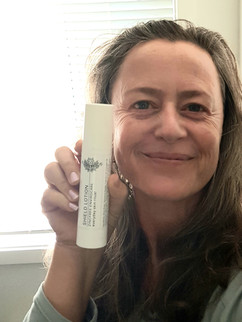 woman holding a white tube of skincare