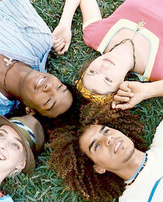 Image of 4 young people lying in the grass wih their heads touching