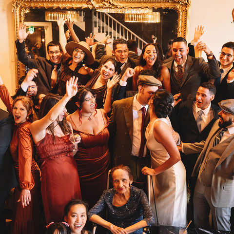 Group photo of the bride, groom, and wedding guests celebrating in the vintage lounge of the National Exchange Hotel in Nevada City