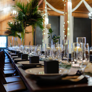 Table setting with tall greenery centerpiece floatng cangles romantic tropical