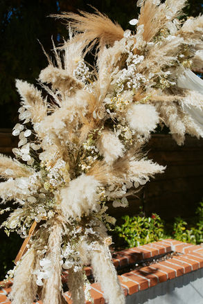 Soft neutral floral ceremony arrangement with textured blooms used during a National Exchange Hotel wedding.