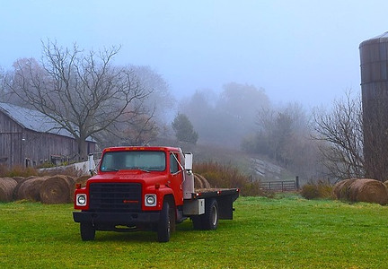 Farm Use only flatbed truck with misty background on green grass.