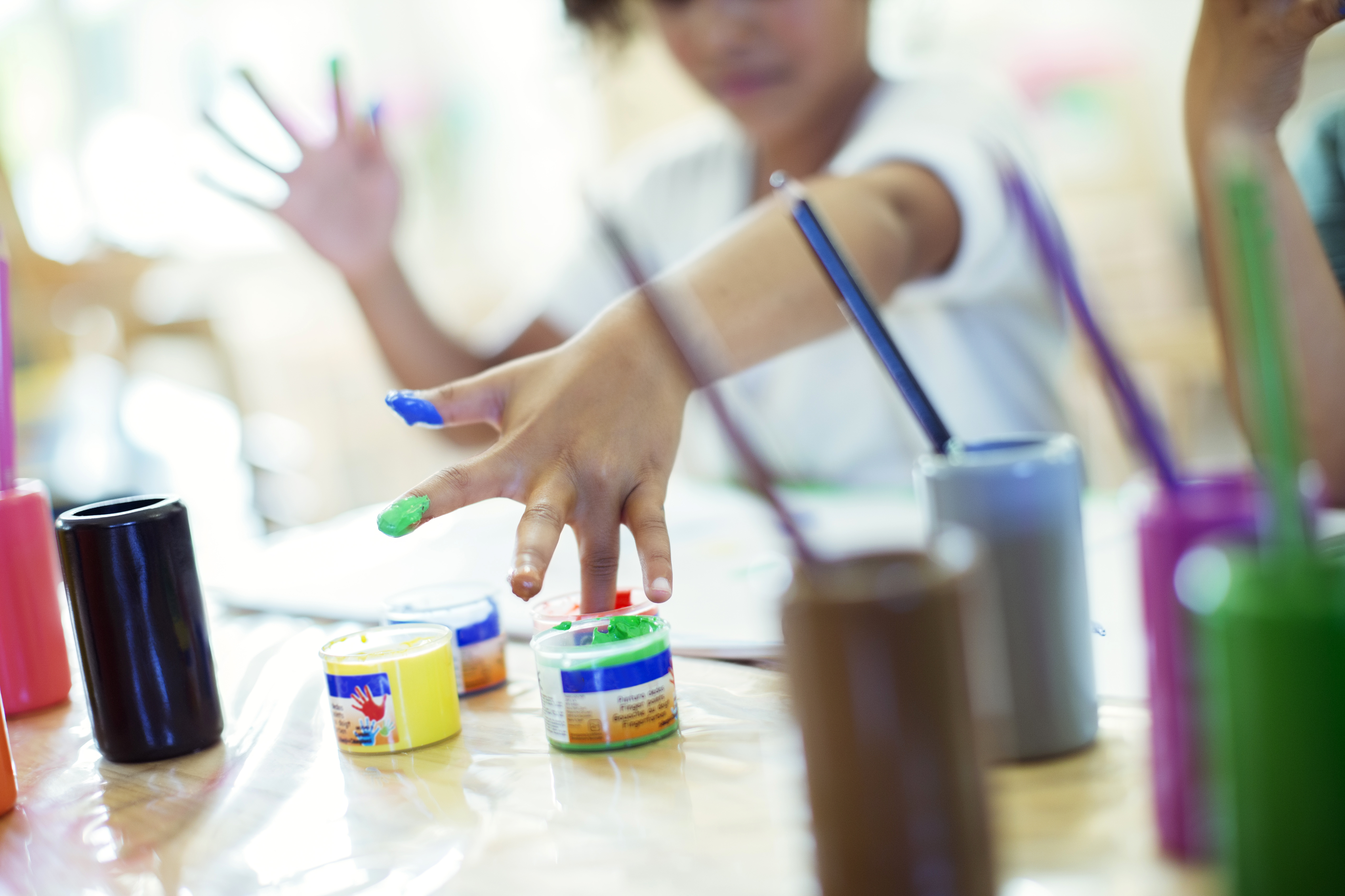 A child using different color paints for painting