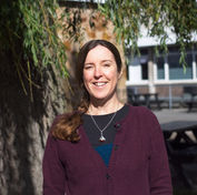 a happy lady outside under a tree in the sun