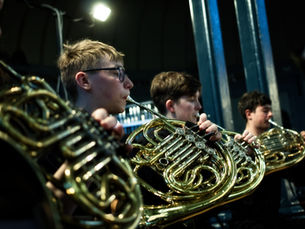 A group of young people playing french horns