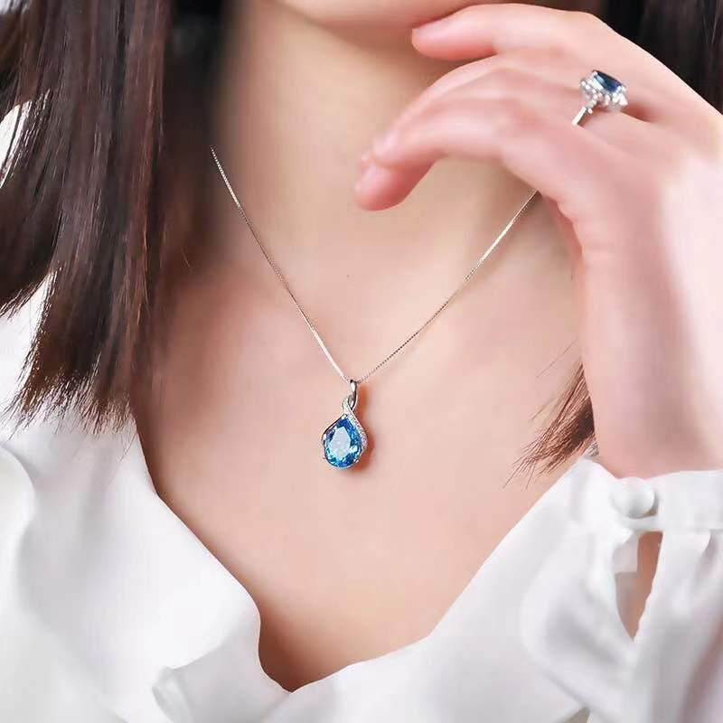 Thumbnail: Woman wearing aquamarine blue teardrop pendant necklace