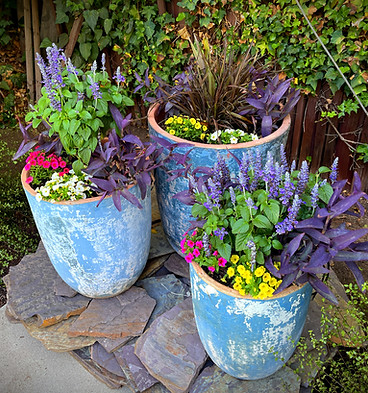 3 rustic potted planters with colorful spring flowers