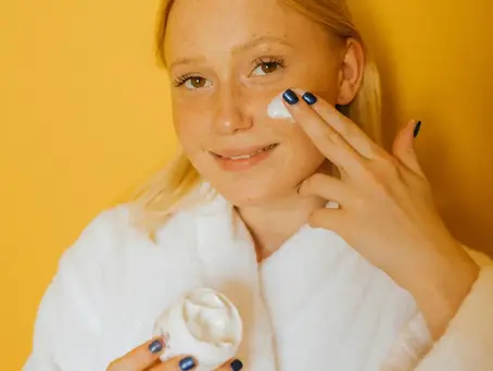 une femme heureuse avec une crème à la main