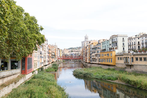 Looking up the Onyar River in Girona towards the cathedral with bright colourful apartment buildings framing each side of the water