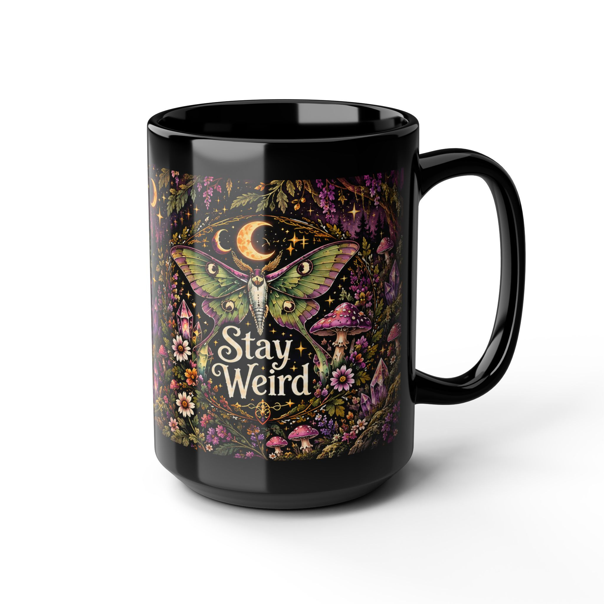 Black Stay Weird mug with a luna moth, crescent moon, mushrooms and wildflowers; angled view, handle right
