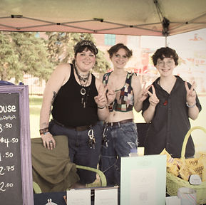 Image of three people from a vendor booth at PrideFest 2025. The button link on the image goes to the PrideFest 2026 Vendor list.