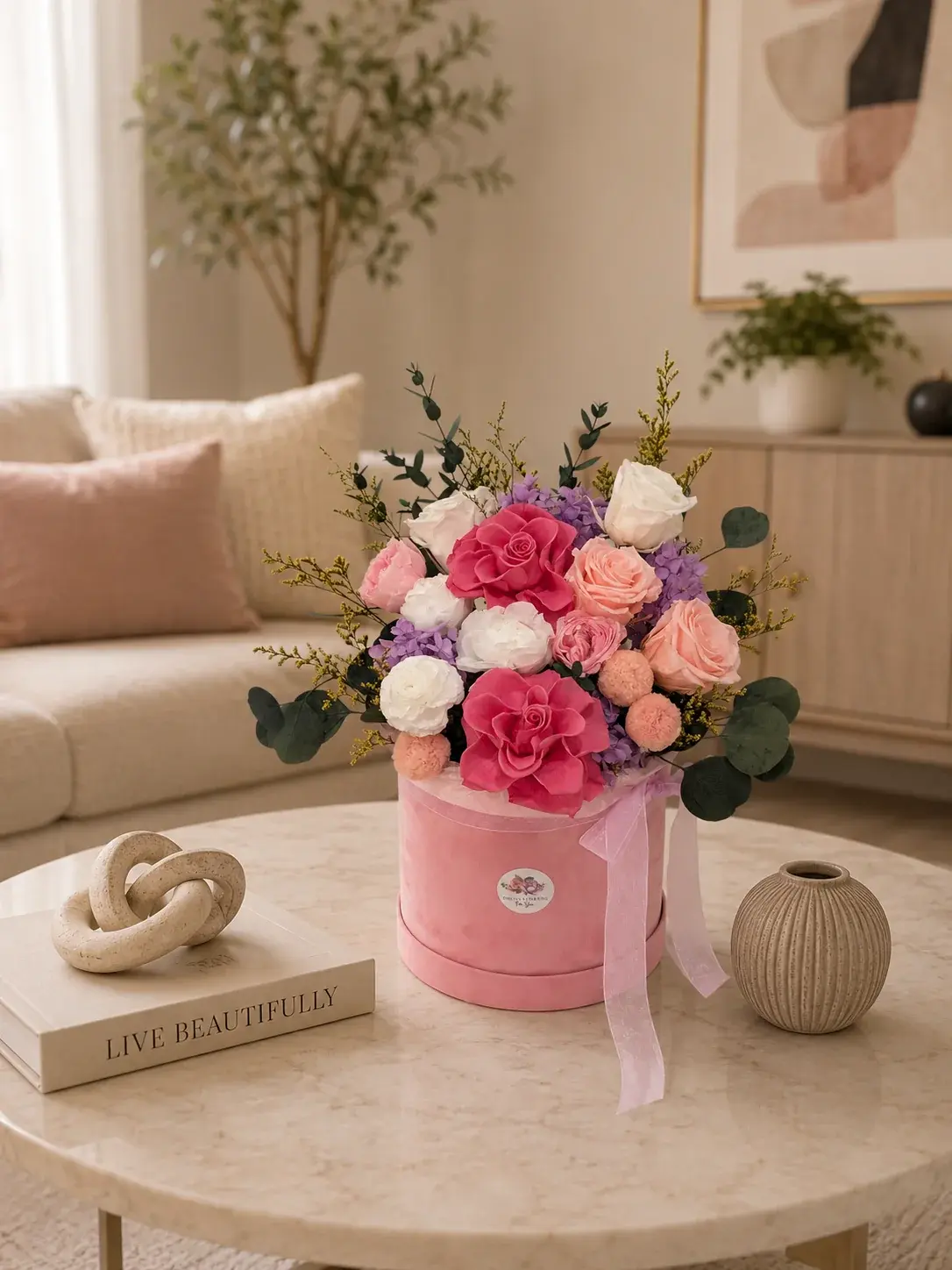 Pastel Dream Garden with pink, peach and white roses, purple hydrangea and eucalyptus on a marble coffee table.