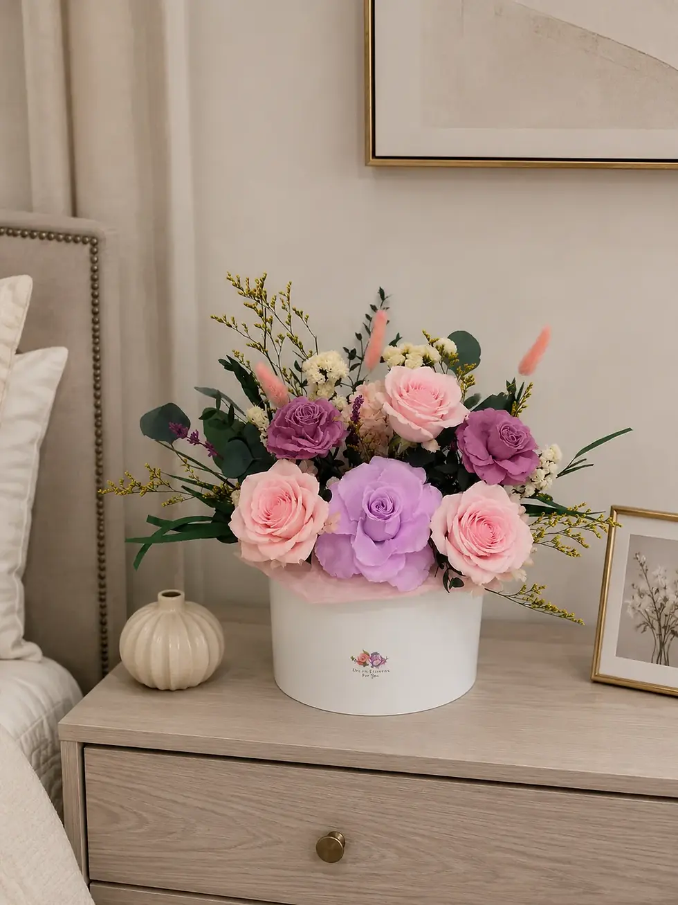 Rosy Lilac Whisper flower box with pink and lilac preserved roses displayed on a bedroom nightstand.