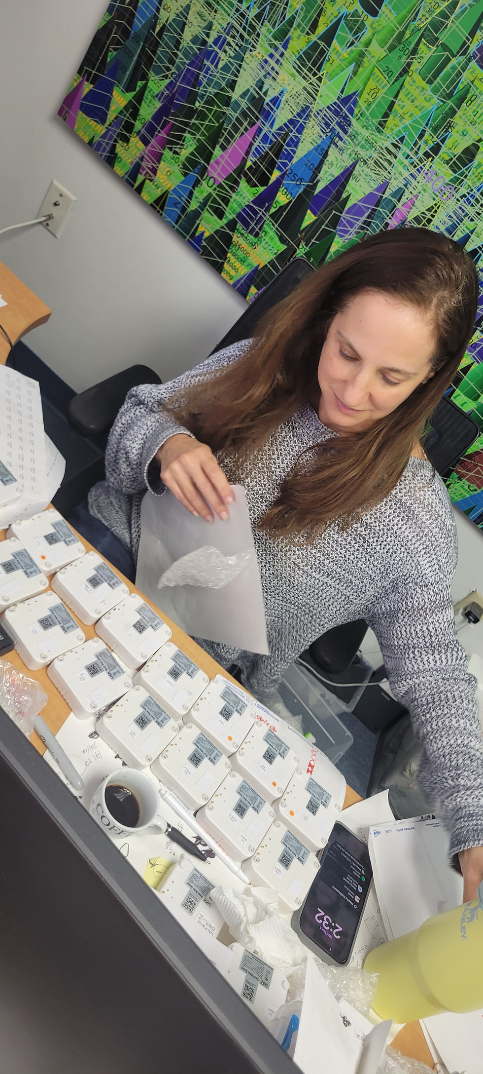 Woman packaging small white boxes at a desk