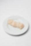 Six raw scallops neatly arranged on a white plate against a plain white background, creating a clean and minimalistic presentation, from Shark Bay, Red Coral Seafood