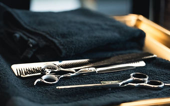 Scissors and combs laid out on a brass tray
