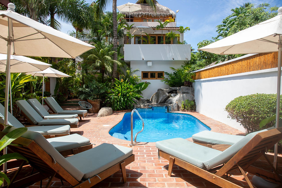 Sun loungers beside a beautiful blue pool in the courtyard of PAL.MAR Hotel Tropical