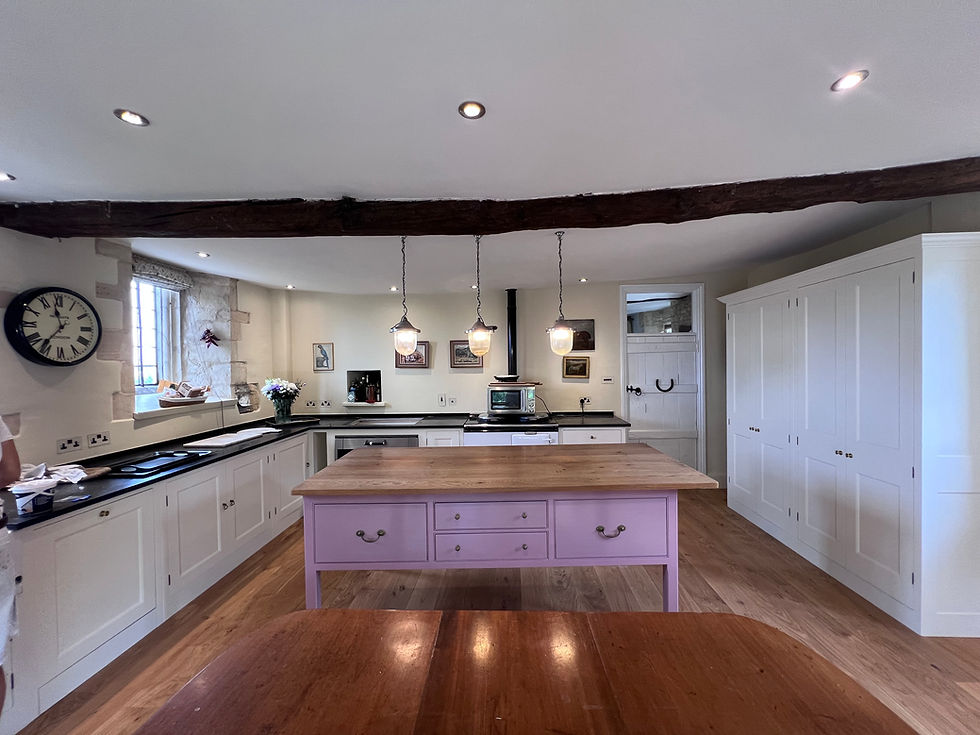 The finished kitchen balances soft neutrals with a polished pink focal point.