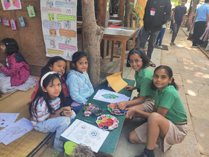 A group of students sitting around a small table, working together on a craft project
