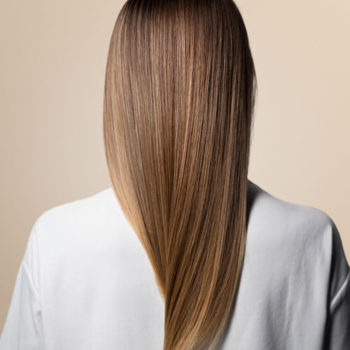 Back view of a woman with long, straight, healthy-looking hair — representing the restorative and strengthening benefits of Hair Loss IV Booster treatments