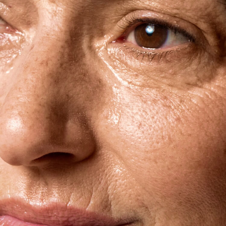 Close-up of mature woman’s face showing natural ageing skin, including fine lines, wrinkles, and skin texture