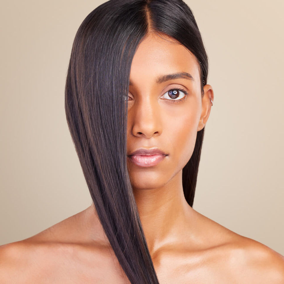 Woman with smooth, healthy, and shiny hair looking confidently at the camera, symbolizing the benefits of mesotherapy for hair loss.