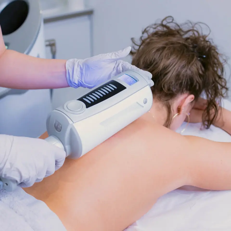 A woman receiving an Endospheres therapy treatment on her back, a non-invasive procedure using a handheld device to improve lymphatic drainage and reduce cellulite