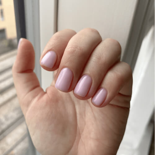 Short, natural nails with a glossy light pink gel polish