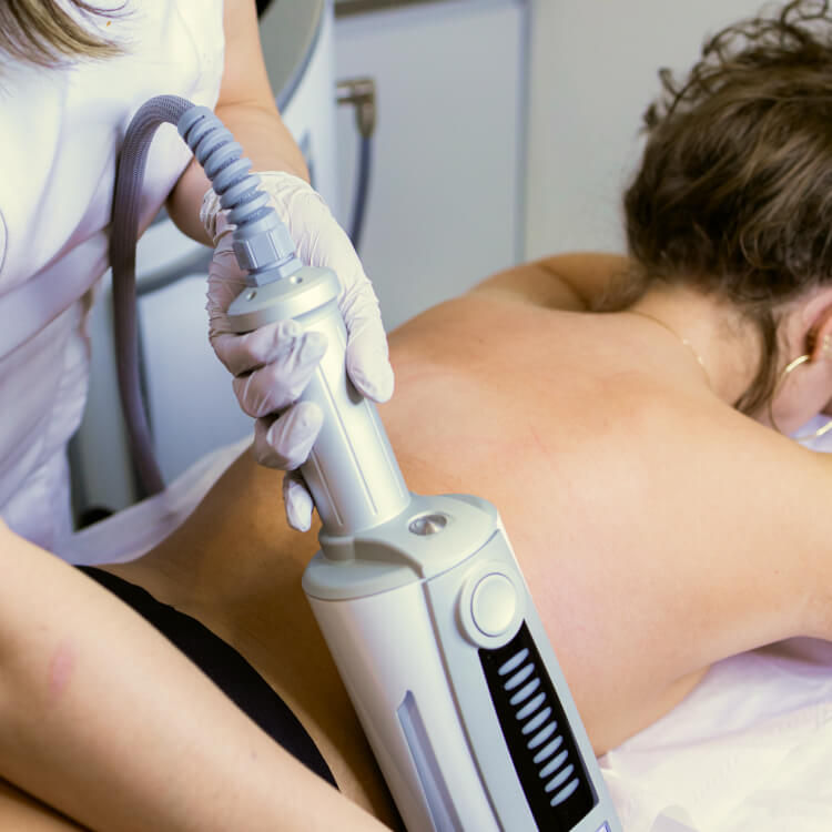 A woman receiving an Endospheres therapy treatment on her back, a non-invasive procedure using a handheld device to improve lymphatic drainage and reduce cellulite