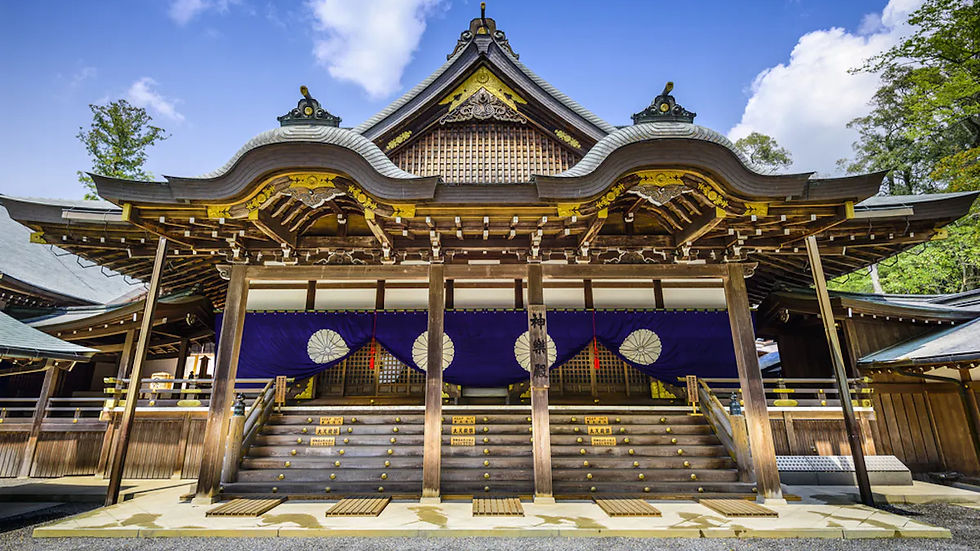 Traditional Japanese shrine with ornate wooden architecture, purple curtains displaying white symbols, and tree-lined background under blue sky.
