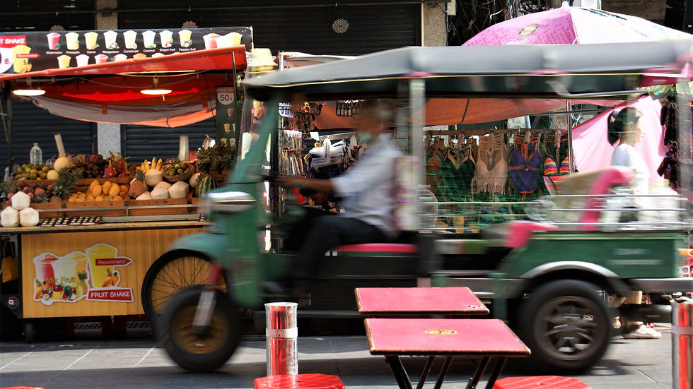 A taxi drives past food stands in the streets of Hanoi