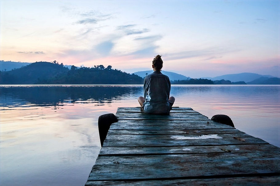 Teenager sitting on a dock overlooking lake and mountains. Represents teen anxiety counseling and therapy for teen anxiety in katy texas and therapy for teen anxiety in houston texas. 77494.