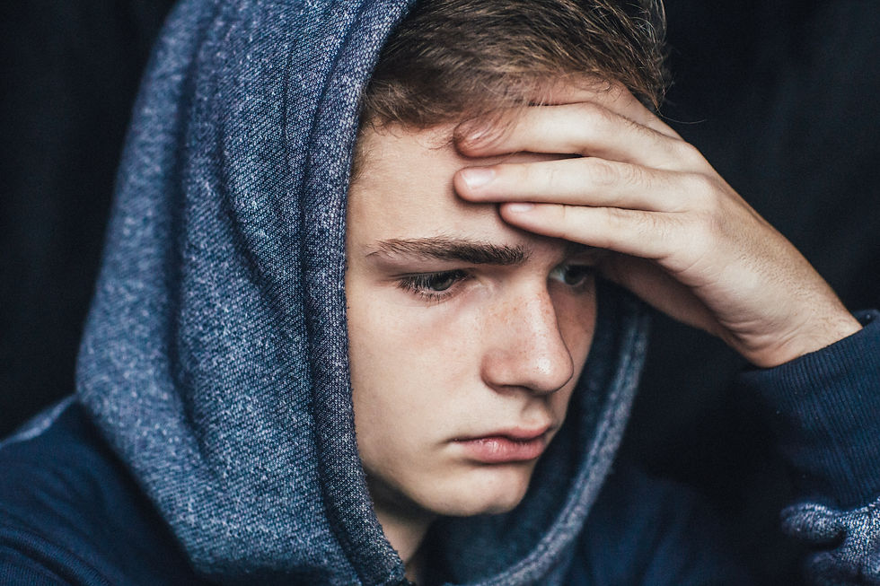 Teen boy hand on forehead looking sad. Represents teen depression requiring teen therapy & teen counseling houston, tx 77494.