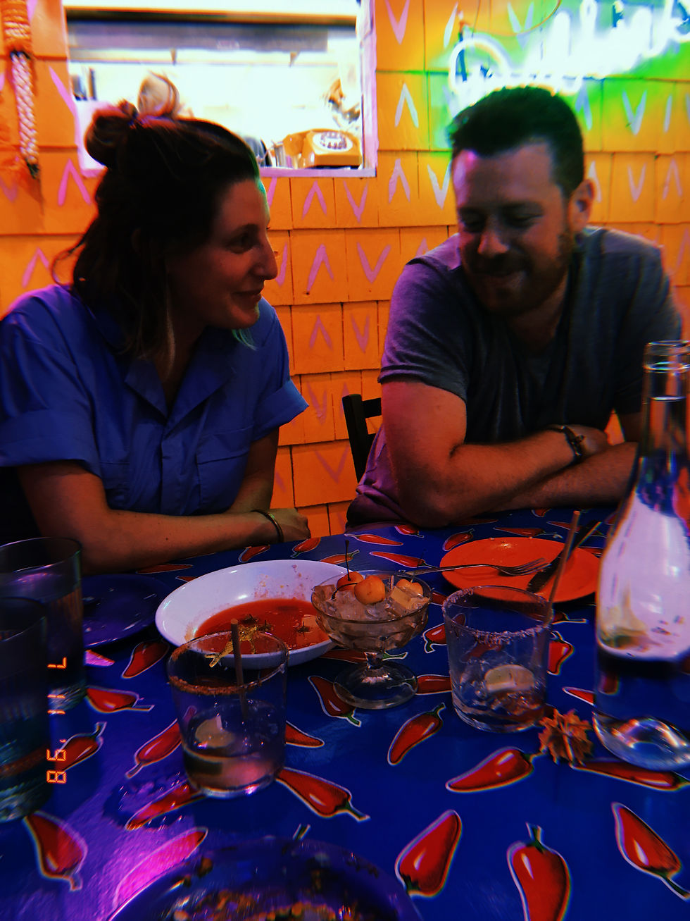 Two diners at a table in Lil’ Deb’s Oasis with a small glass cup of cherries on ice between them.