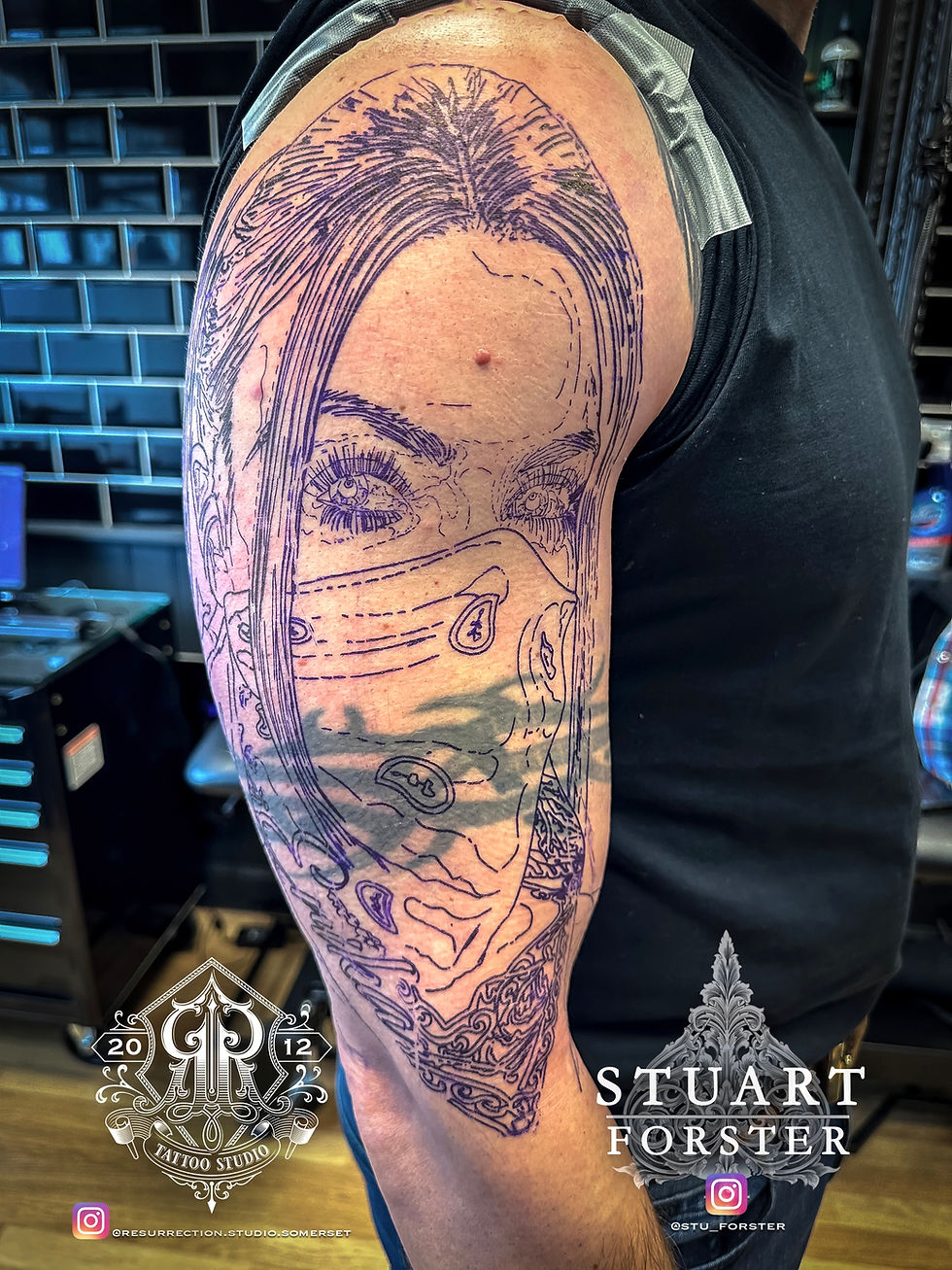 Tattoo cover up stencil placed over an old tattoo on upper arm, showing the design process for a realism cover-up tattoo.