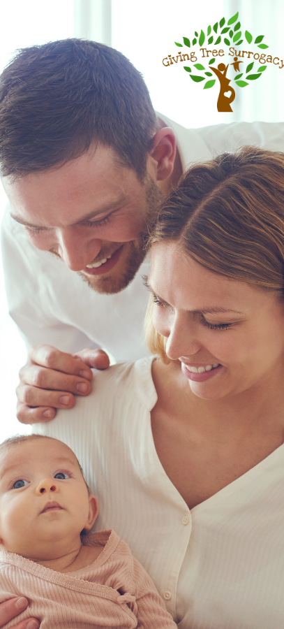 Smiling couple looking lovingly at their baby, symbolizing the beginning of a family through surrogacy