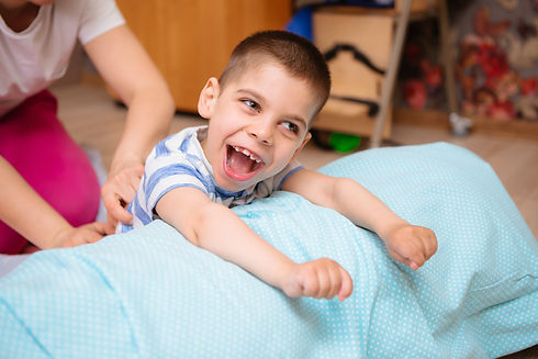 little kid with cerebral palsy has musculoskeletal therapy by doing exercises in body fixi