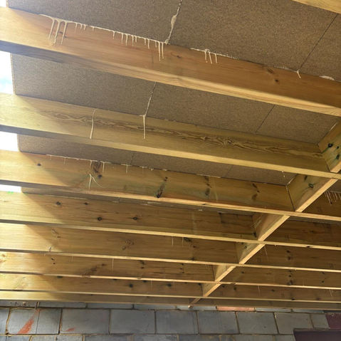 looking up at a newly built flat roof, exposed joists