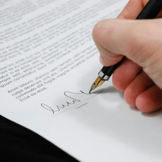 a photo of someone signing a legal document 