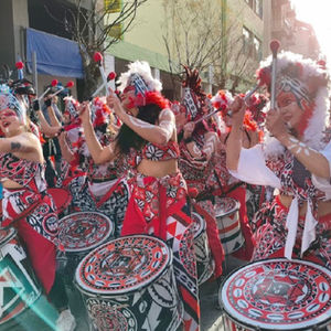 Batala Manchester playing drums at a parade.