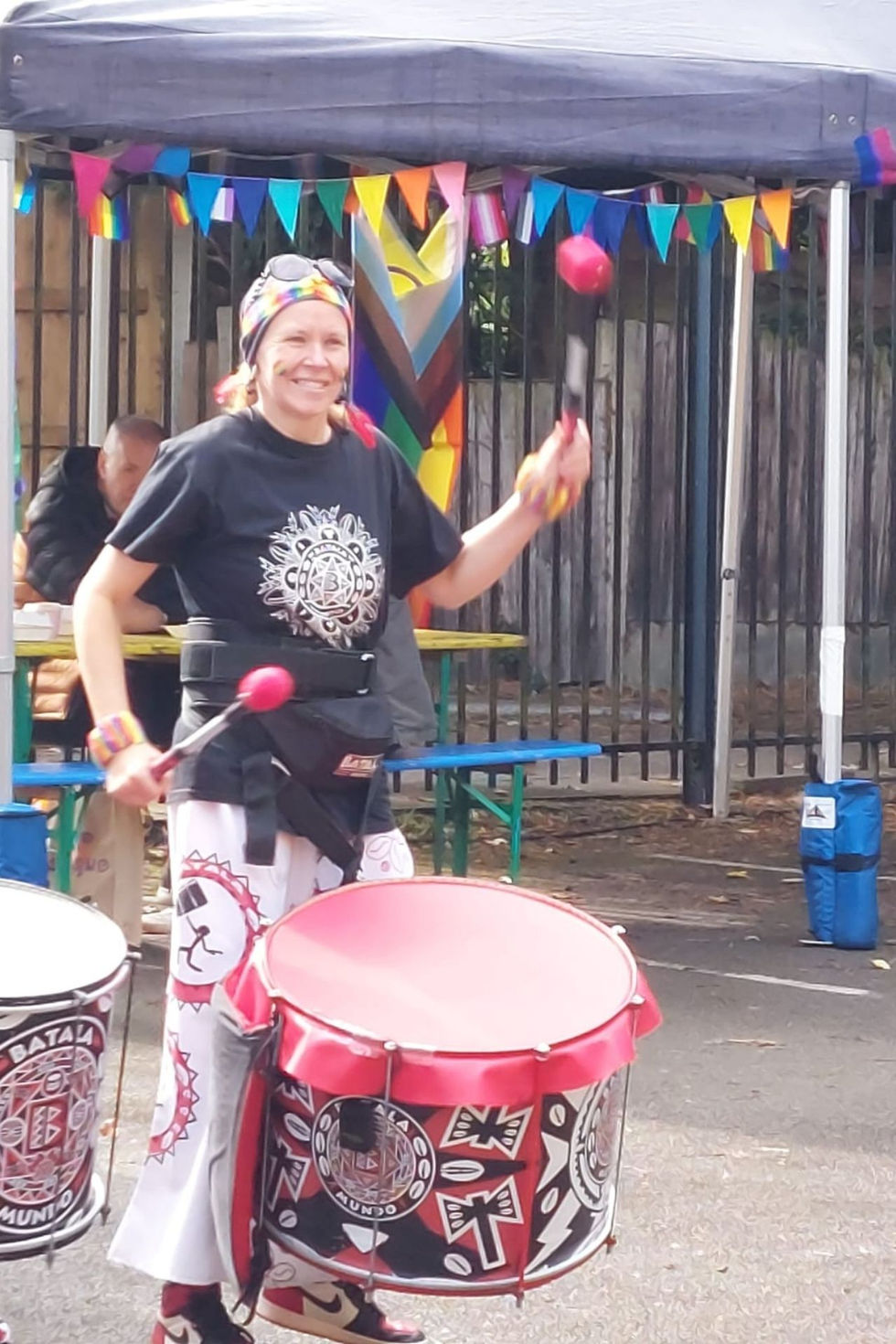 One female Batala player banging a red drum
