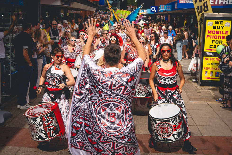 A Batala caller facing the players as they parade
