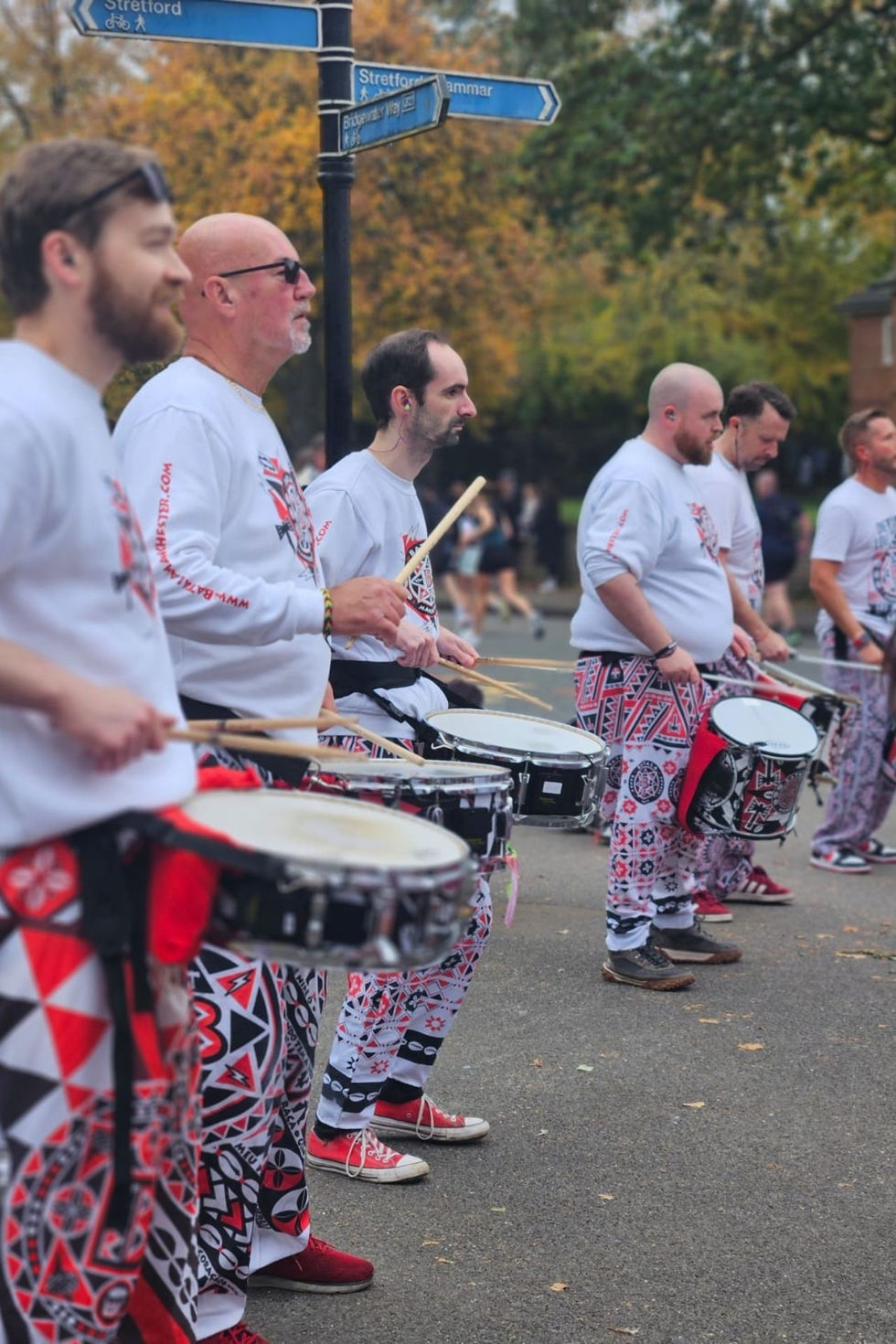 Caixa and repi players playing while standing in a row
