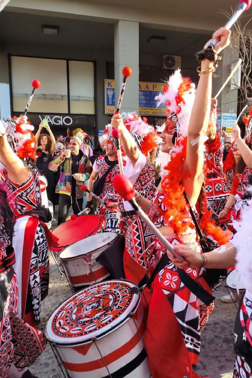 People in colorful costumes playing drums in a parade.