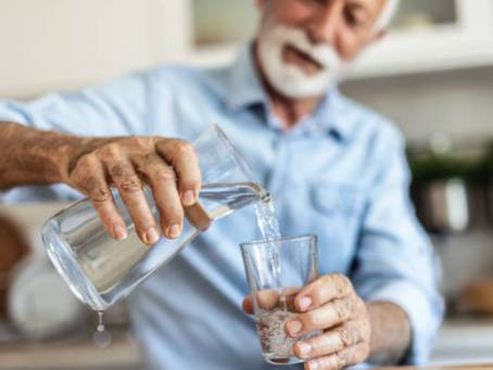 Personne âgée se servant un verre d’eau pendant une journée ensoleillée