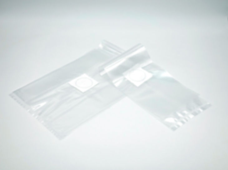 Two clear sterile bags with white filter patch on light background.