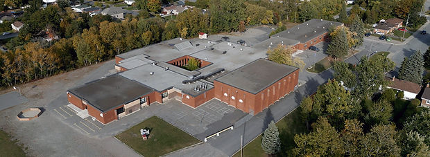Aerial view of the Sudbury Academy facility, showing some parking and elementary entrance way.