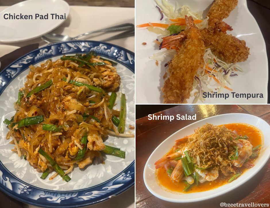 Chicken Pad Thai on a blue-white plate, crispy Shrimp Tempura, and vibrant Shrimp Salad on white dishes, each labeled, on a wooden table.
