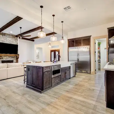 Open kitchen and living room with exposed beams and a dark wood island in The Motherlode