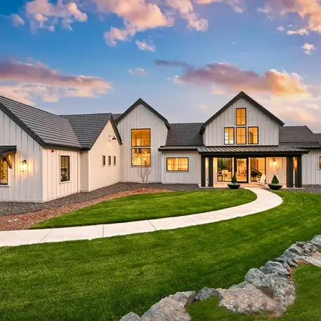 Modern farmhouse custom home lit at dusk with a curved walkway in Meadow Vista, CA